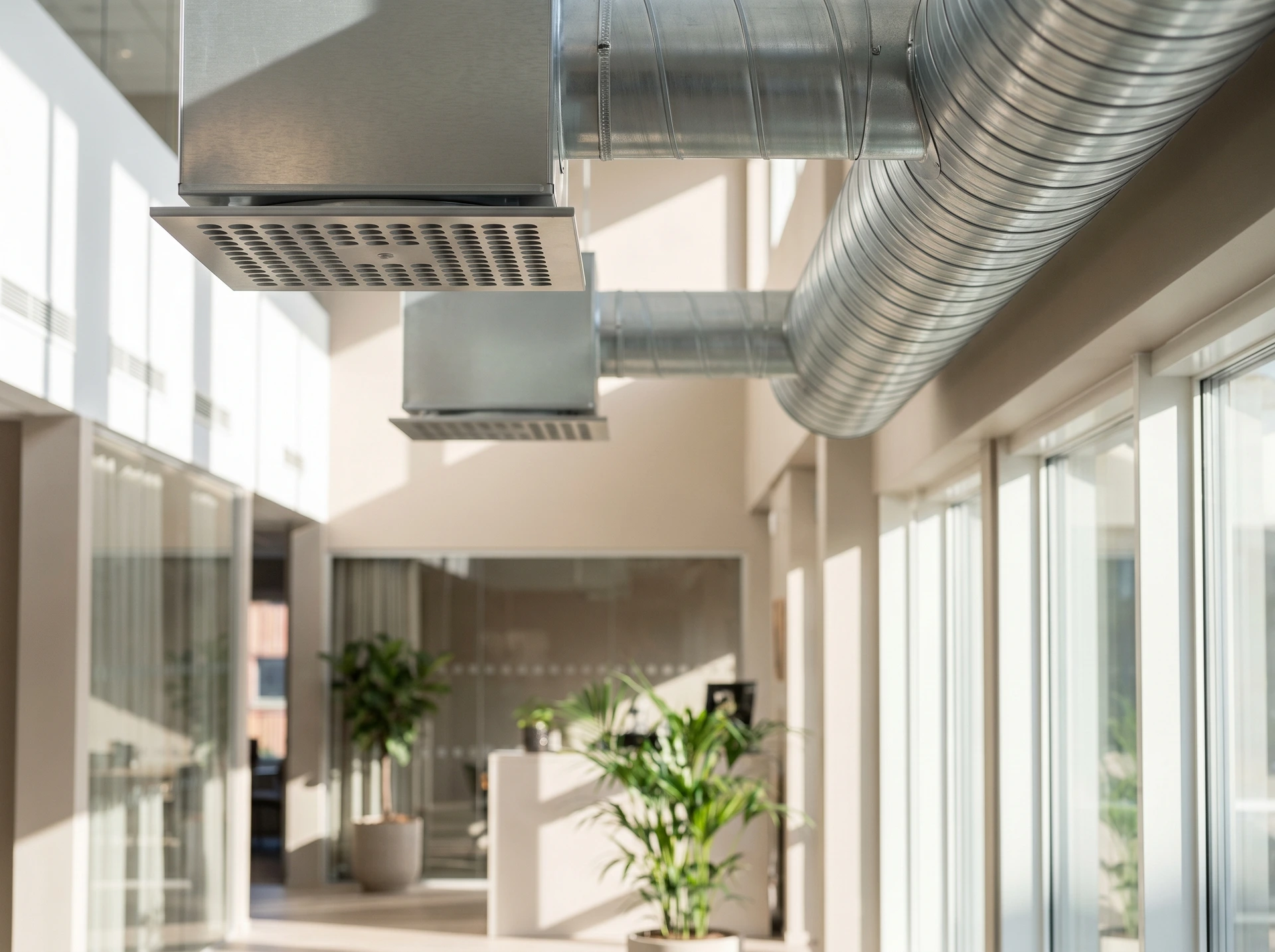 Ventilationsrör och luftdon i taket på ett modernt kontorsbyggnad.